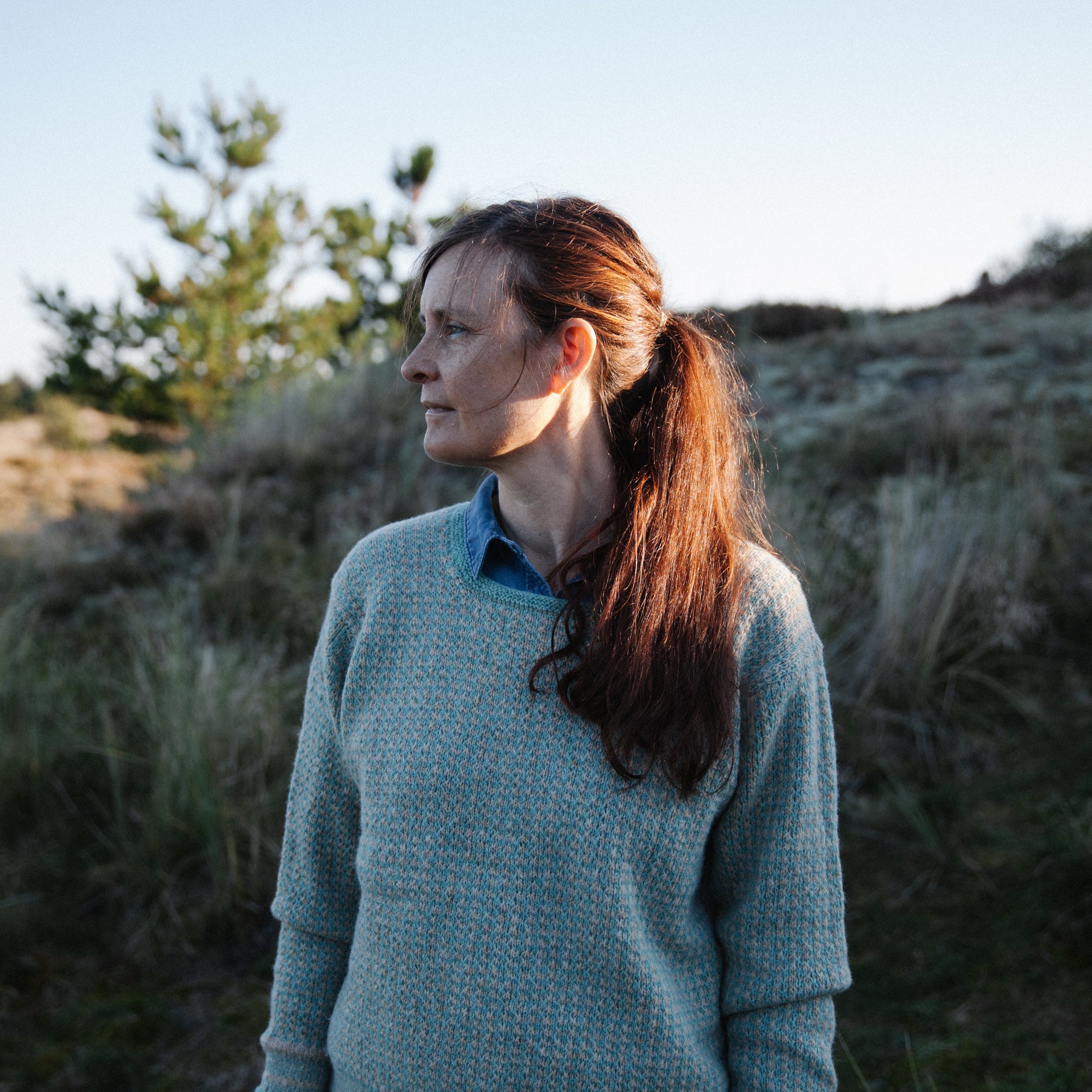 A woman wearing a handknitted Biches & Bûches sweater, seen from the front