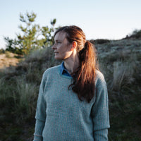 A woman wearing a handknitted Biches & Bûches sweater, seen from the front