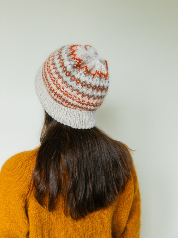 A woman wearing a handknitted hat, seen from the back