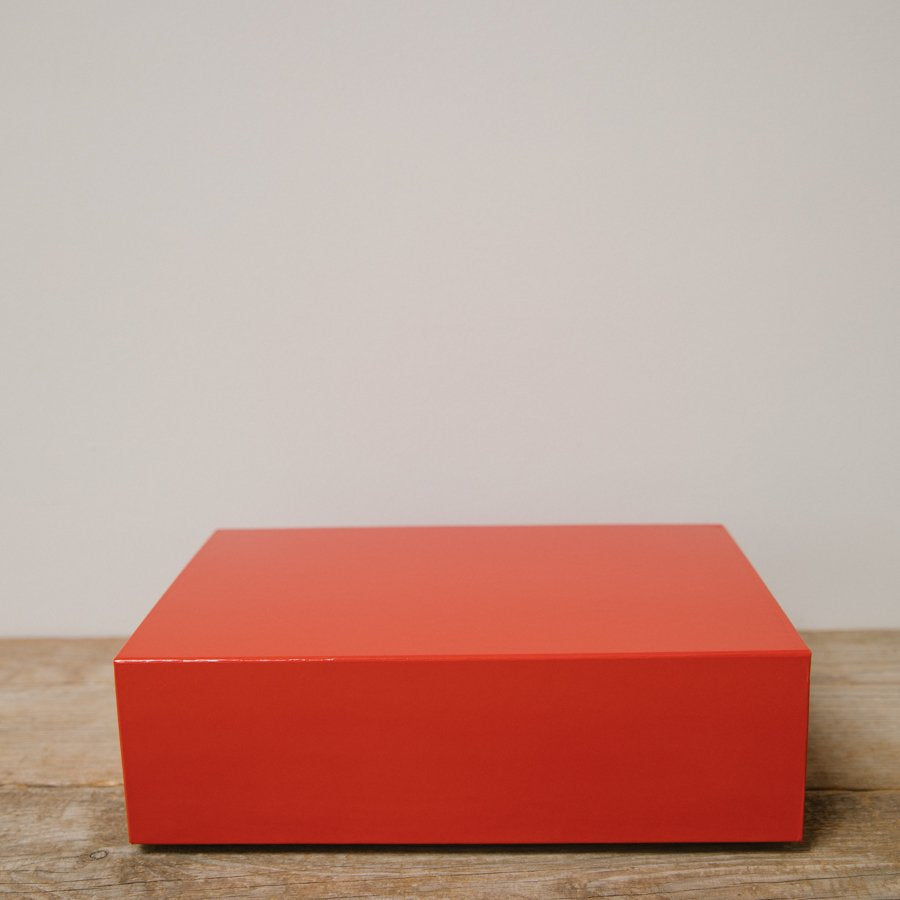 A red Biches & Bûches gift box on a wooden table