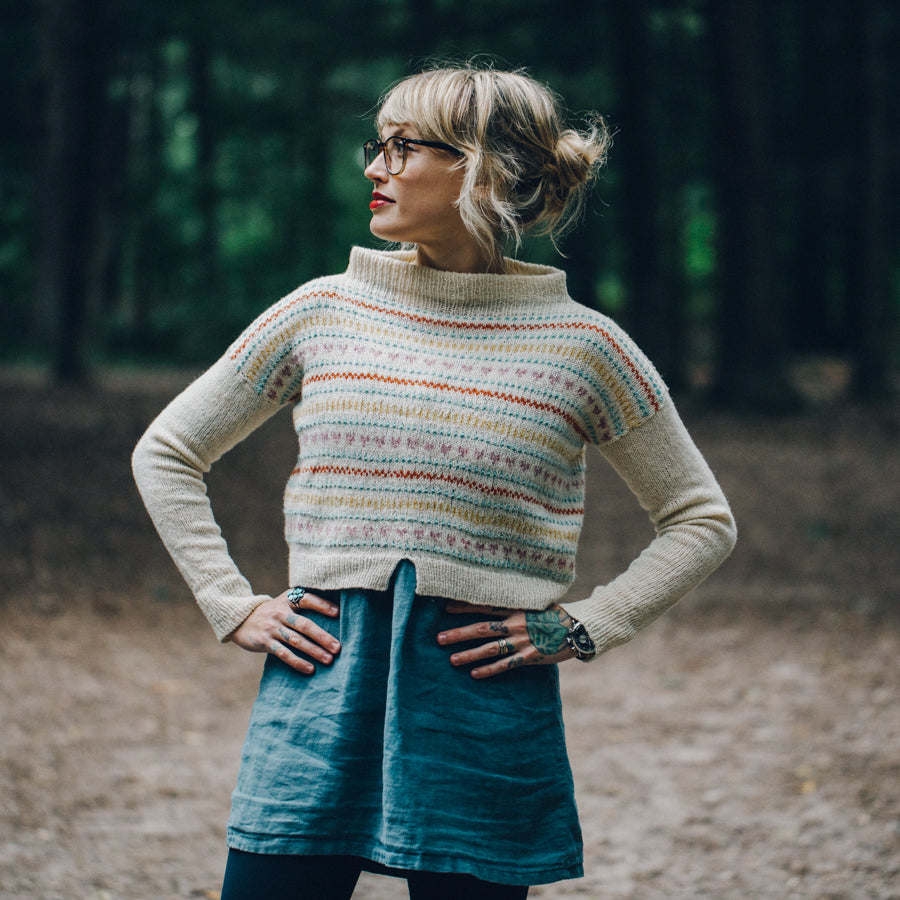 Andrea Mowry is wearing a stranded handknitted sweater, seen from the front